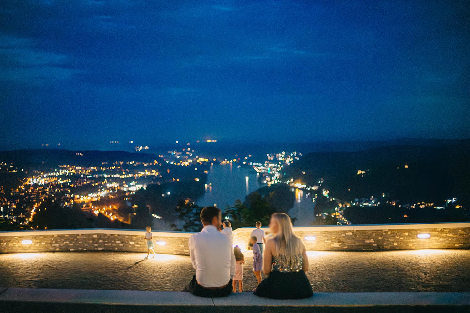 Hochzeitsgäste genießen während der Blauen Stunde die abendliche Aussicht von der Drachenfels-Terrasse auf den Rhein.