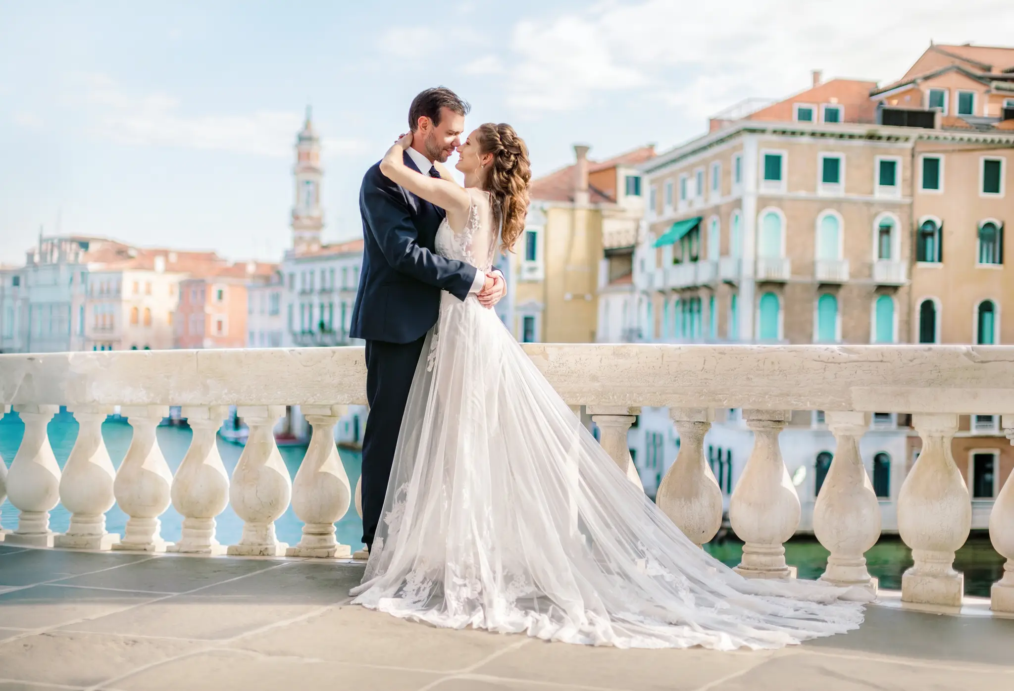 HOCHZEITSFOTOGRAF VENEDIG 56 Brautpaar Stirn an Stirn auf einer Steinterrasse mit Blick auf den Canal Grande und die pastellfarbenen Palazzi. Intimes Paarshooting beim After Wedding Shooting in Venedig.