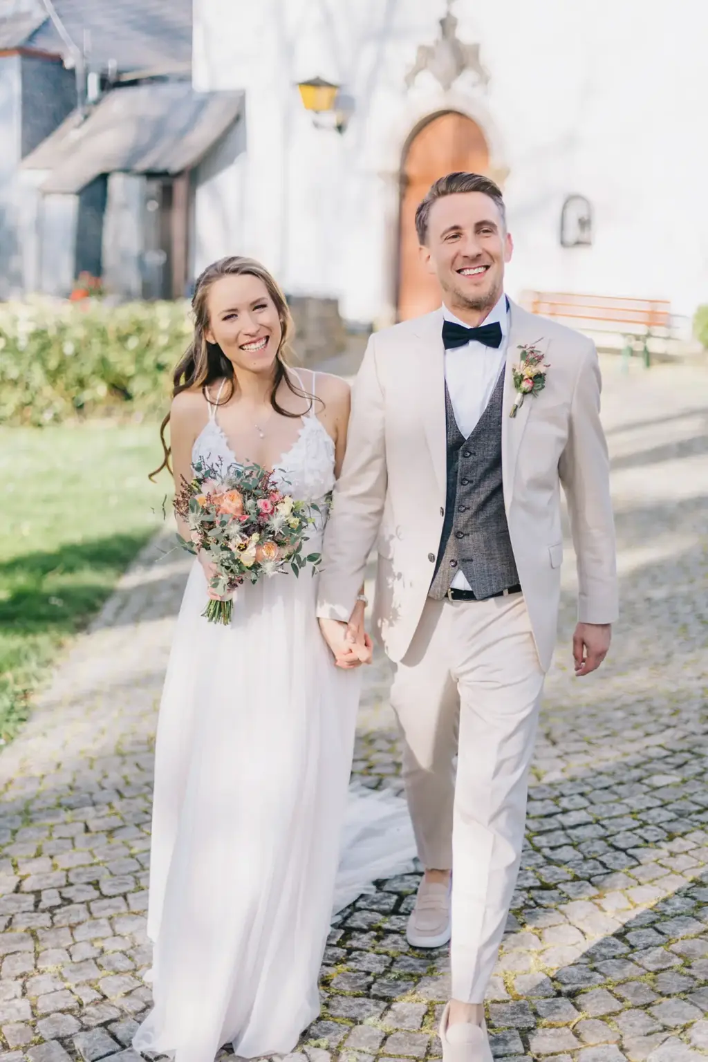 HOCHZEIT GODESBURG BONN 134 räutigam flüstert seiner Braut ins Ohr bei Paarfotos auf der Godesburg Bonn